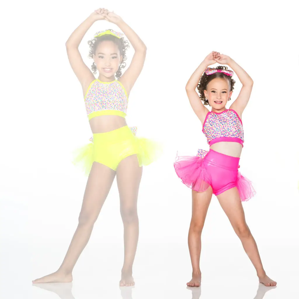Two young dancers in colorful sequined costumes posing