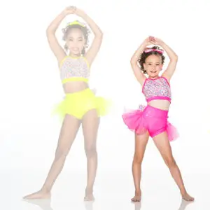 Two young dancers in colorful sequined costumes posing