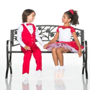 Children in red costumes holding hands on a bench