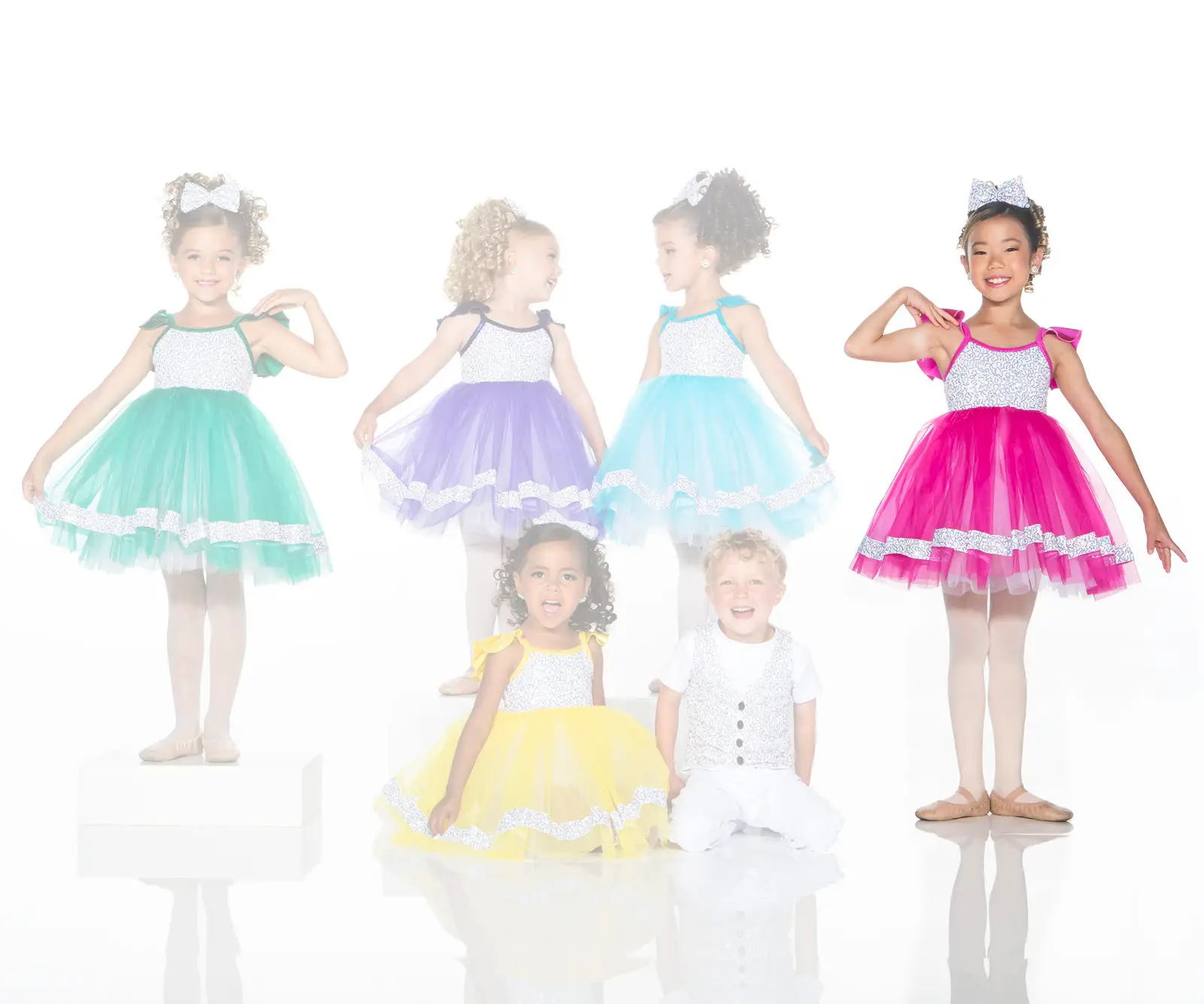Children modeling colorful dance costumes against a white background
