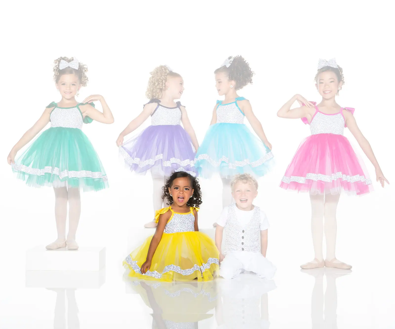 Children modeling colorful tutu dresses and a white vest