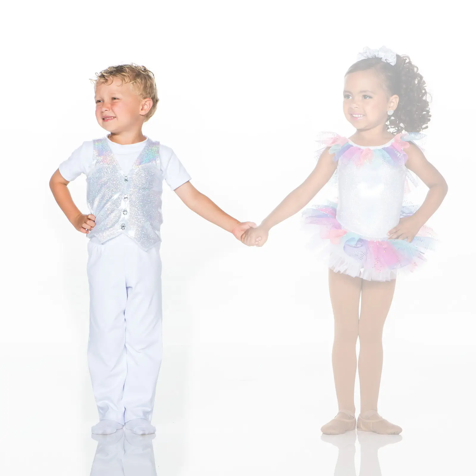 Young boy and girl holding hands in glitter costumes