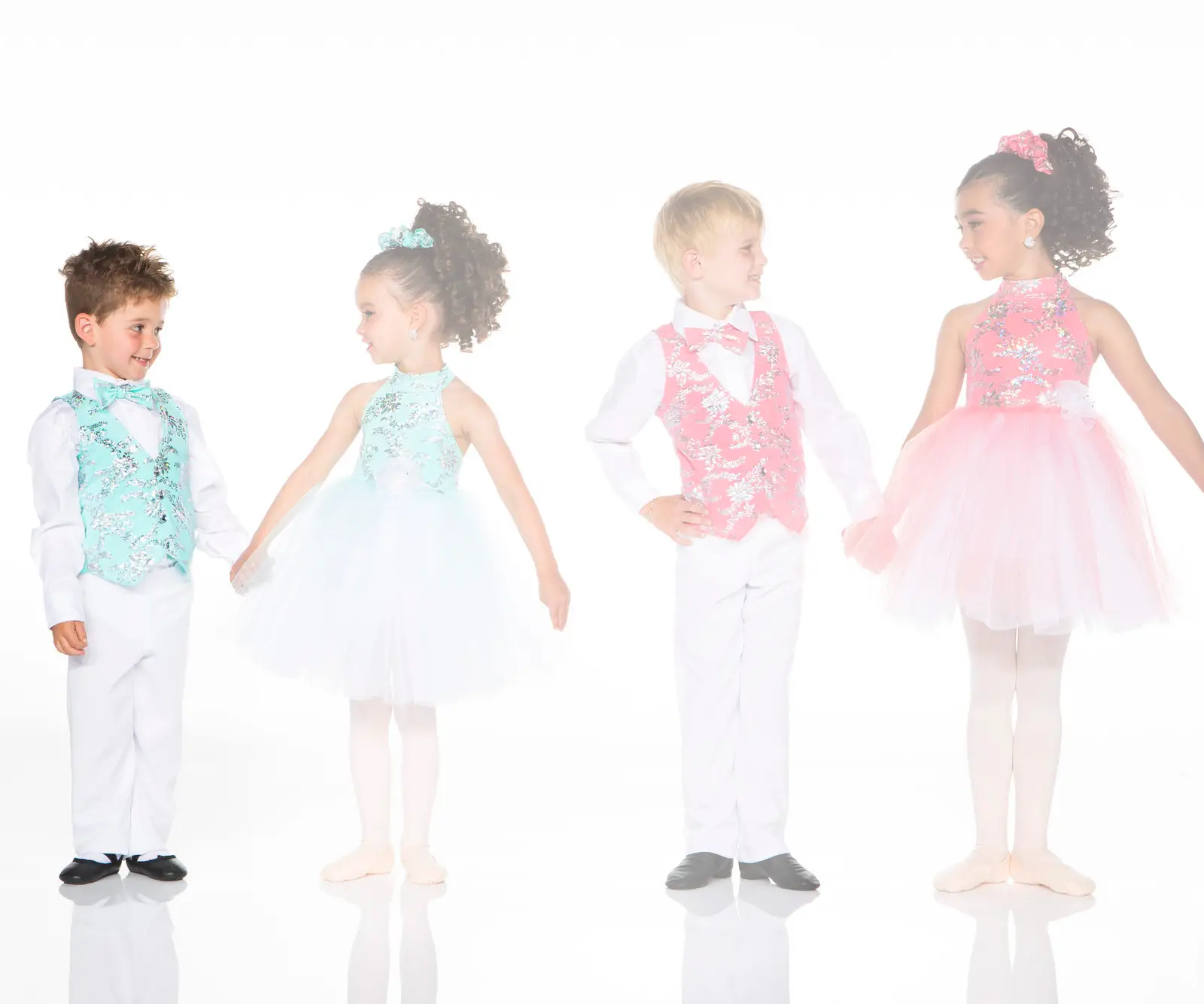 Four children wearing colorful formal dance costumes