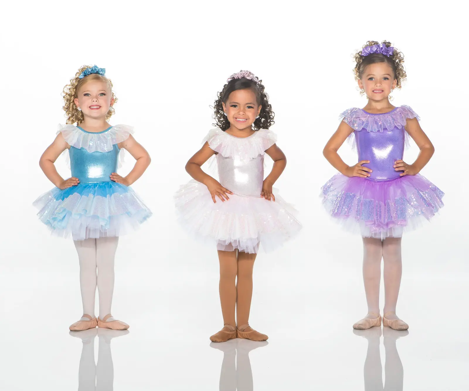 Three young girls wearing colorful sparkly ballet costumes