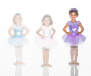 Three young ballerinas wearing blue, white, and purple tutus