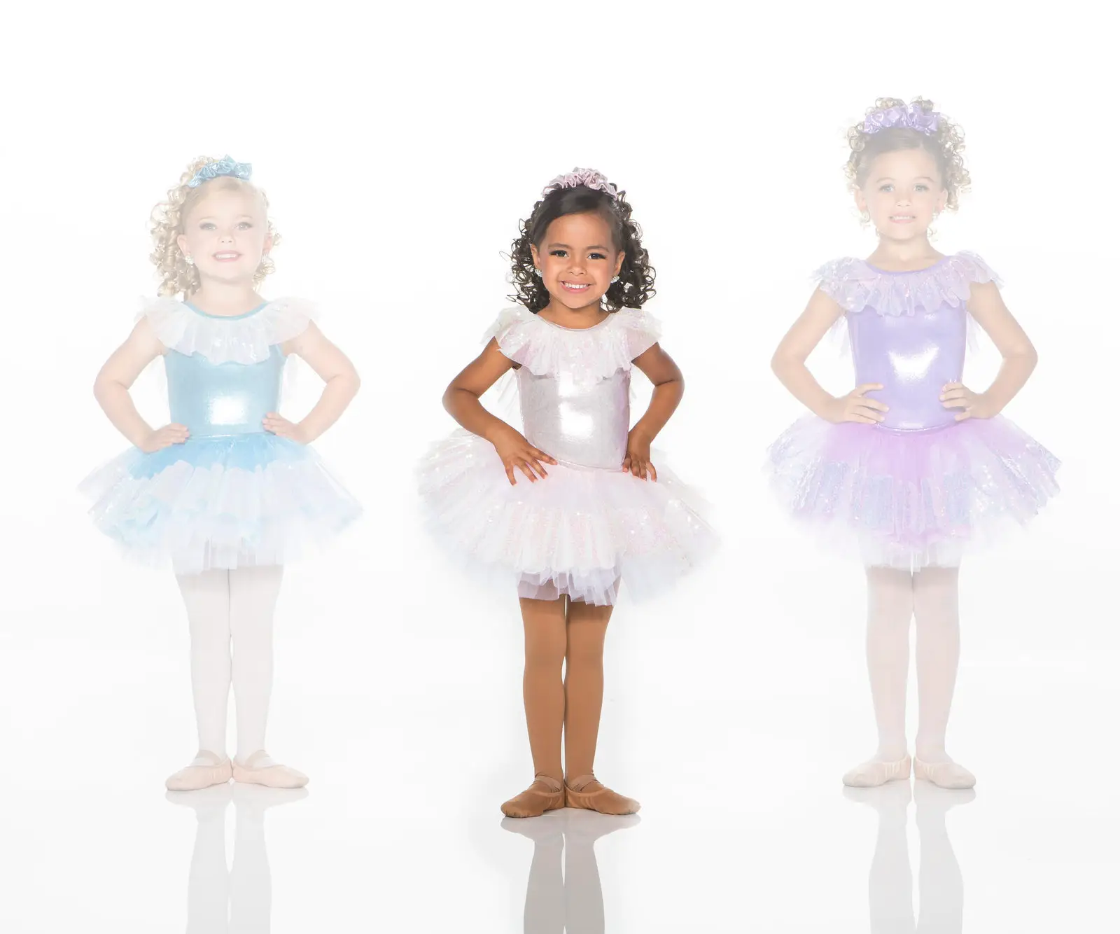 Three young ballerinas wearing pastel sparkly tutus