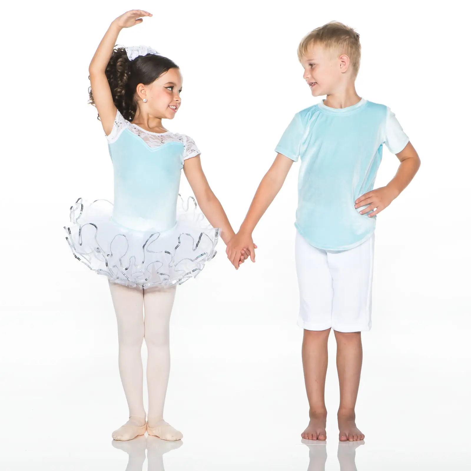 Young ballet dancer and boy holding hands in blue outfits