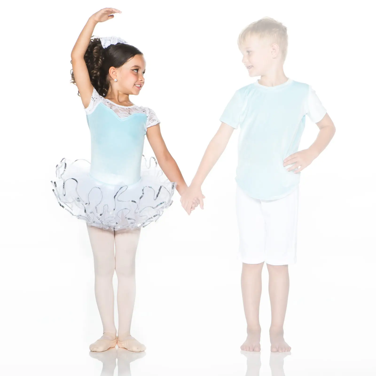 Young ballerina and boy holding hands on white background