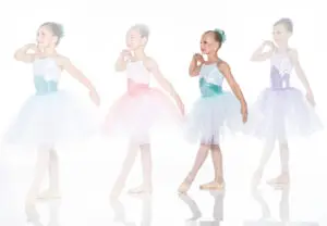 Four young ballerinas in pastel tutus pose against white background.