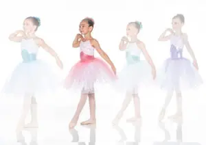 Four young ballerinas posing in colorful tutus