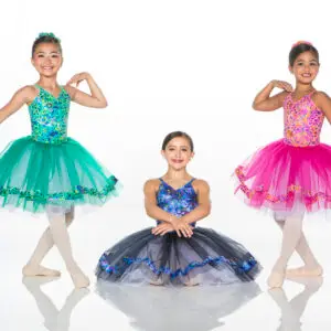 Three young ballet dancers in colorful tutus posing