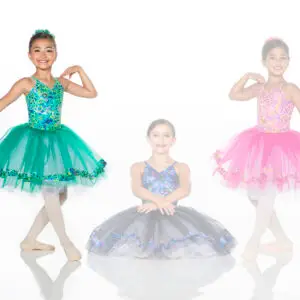 Three young ballet dancers wearing colorful tutus against white background