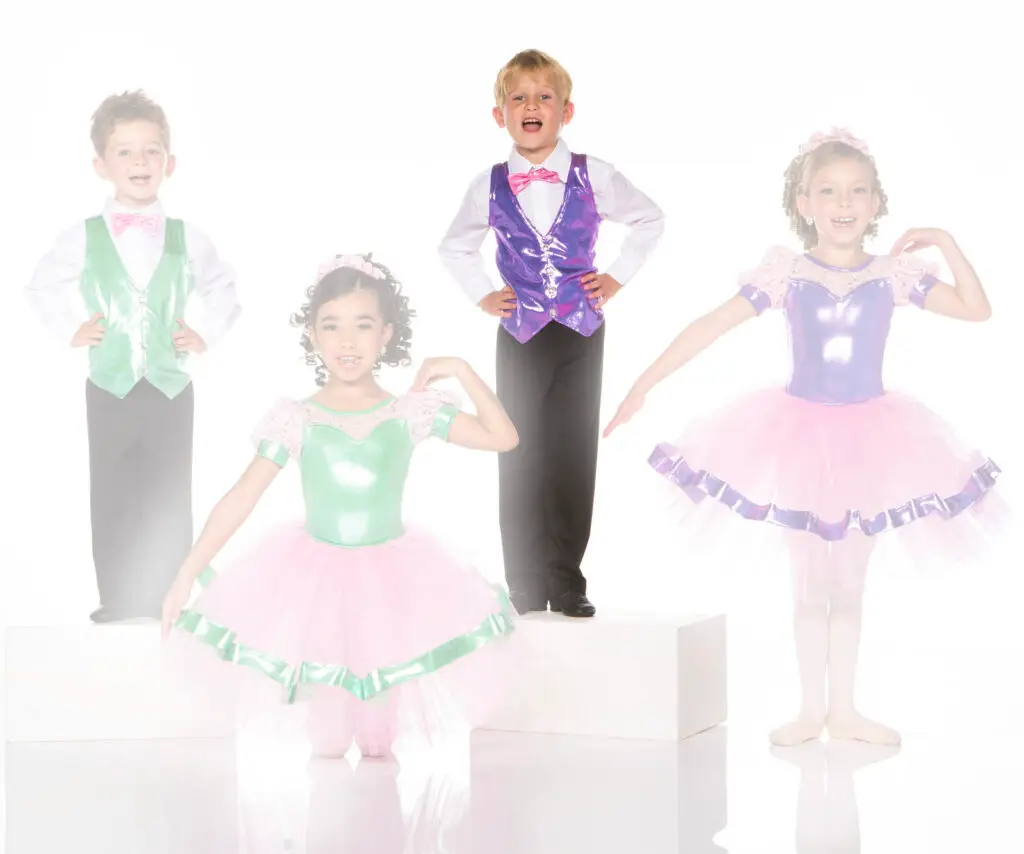 Children wearing colorful dance costumes pose in a studio
