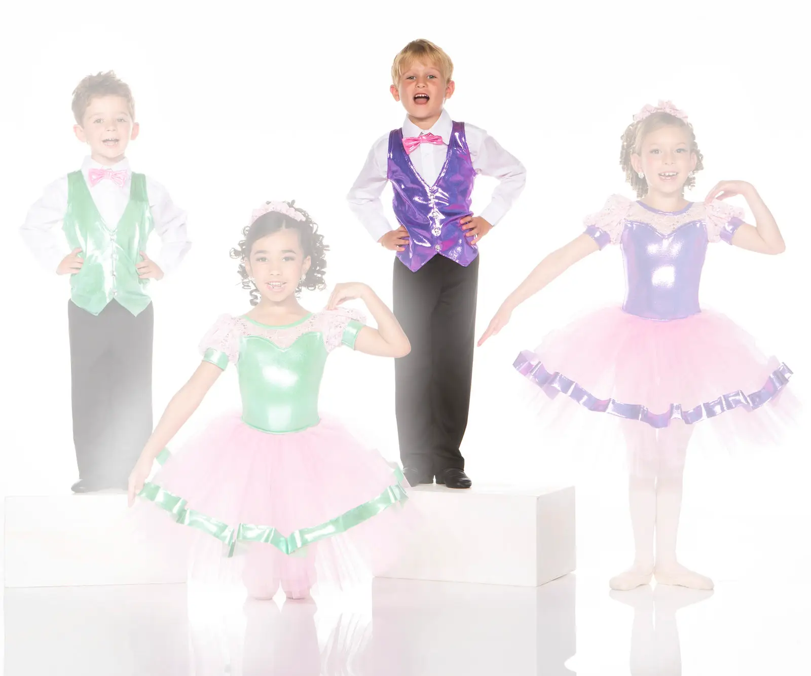 Children wearing colorful dance costumes pose in a studio