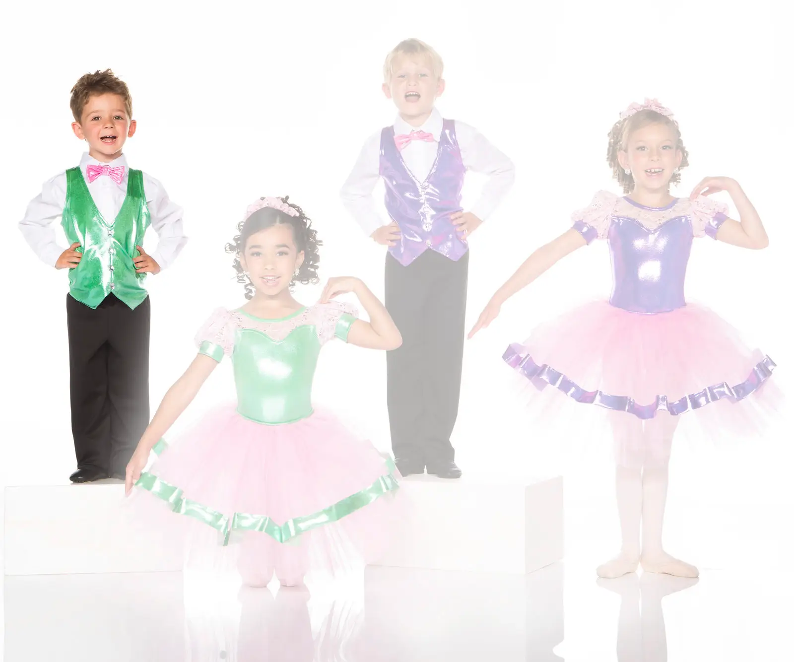 Four children in colorful dance costumes posing in studio