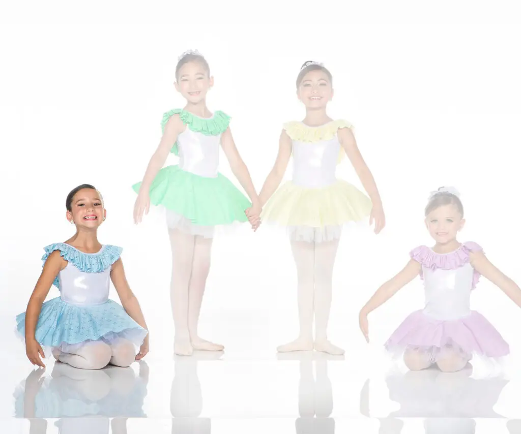 Four young ballet dancers wearing colorful tutus