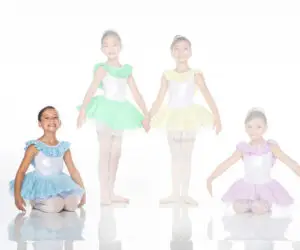 Four young ballet dancers wearing colorful tutus