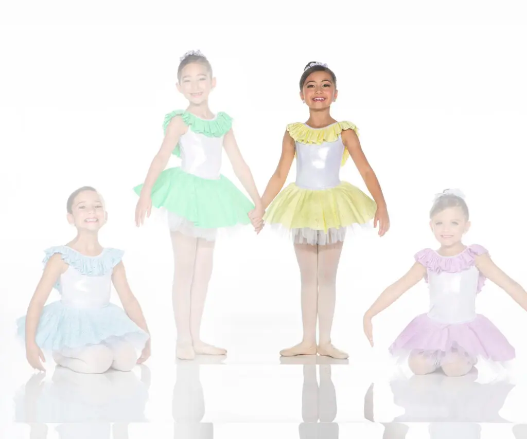 Four young ballerinas wearing pastel ruffled tutus pose together