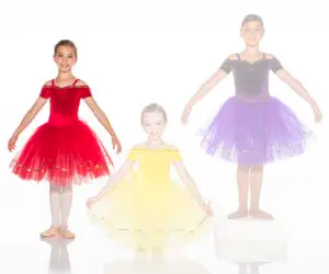 Three young ballerinas wearing red, yellow, and purple tutus