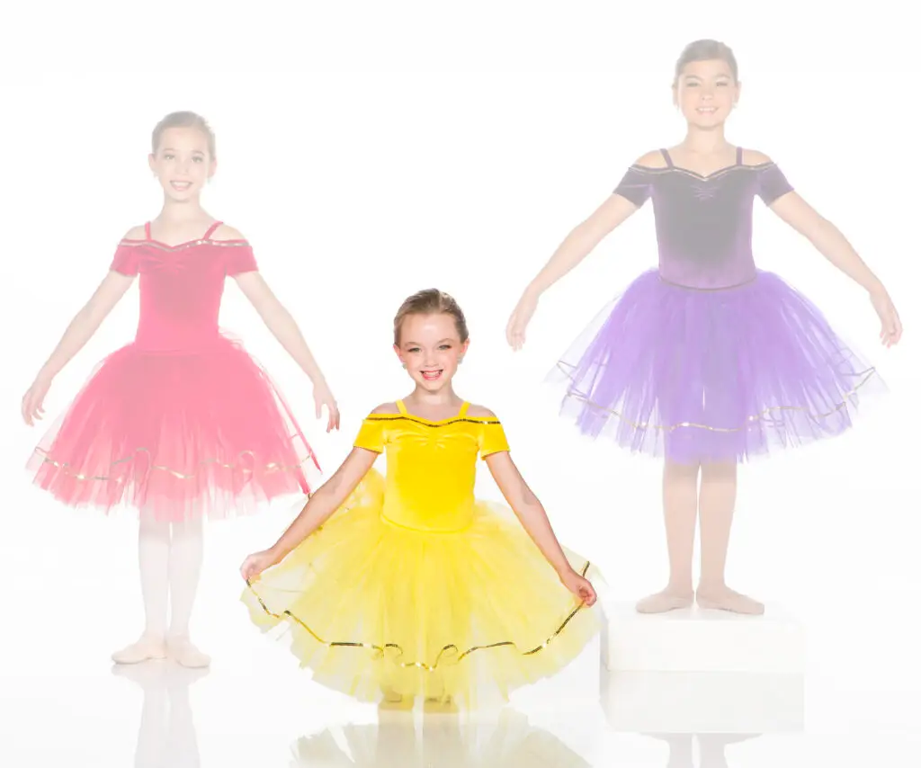 Three young ballerinas in colorful tutus against a white background