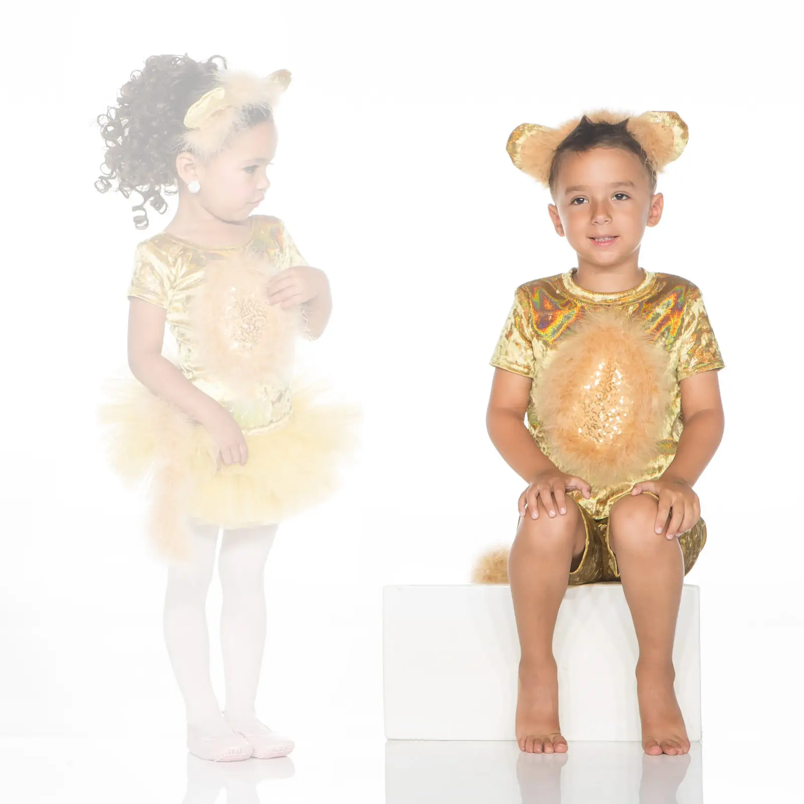 Children wearing gold bear costumes against a white background