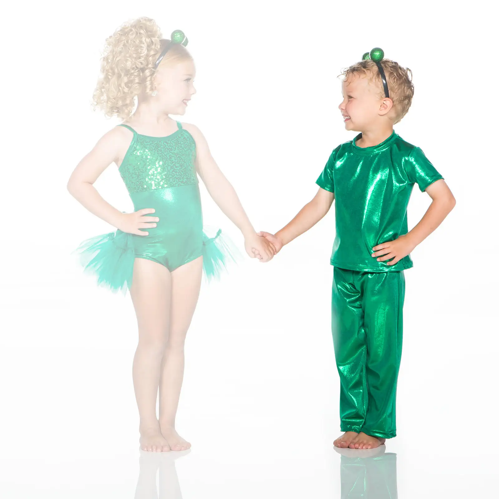 Two children in green costumes holding hands