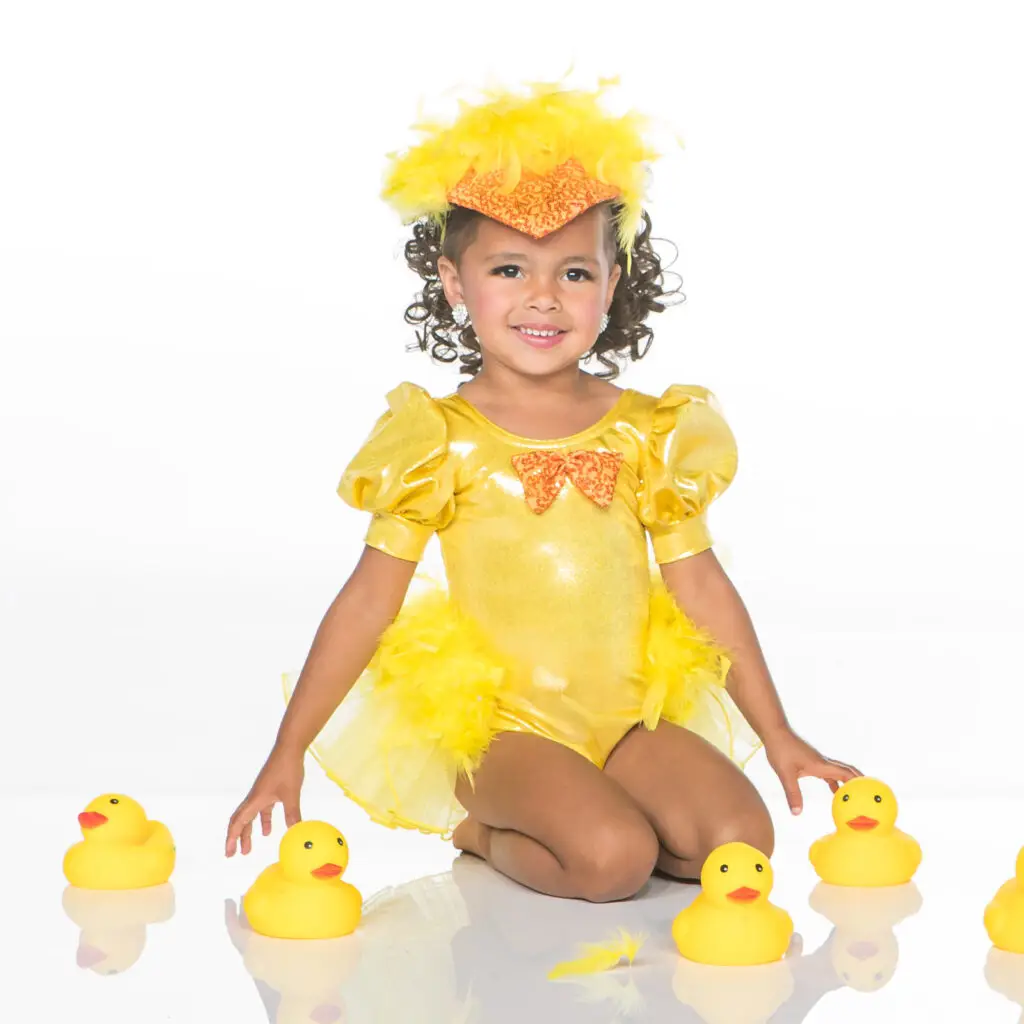 Young girl in yellow duck costume surrounded by rubber ducks