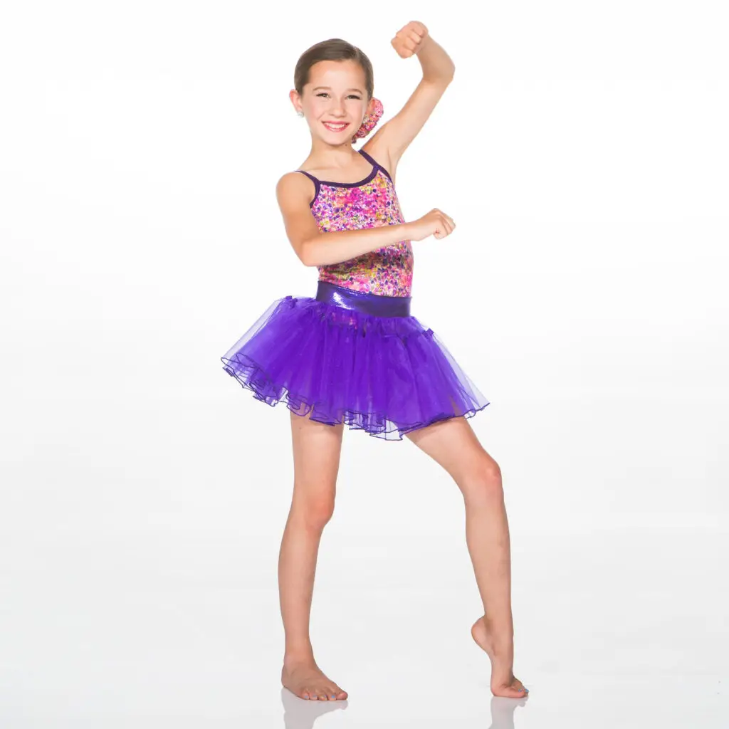 Smiling young dancer in colorful leotard and purple tutu