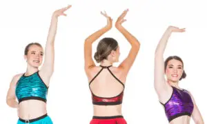Three dancers model colorful tiger-print performance tops.
