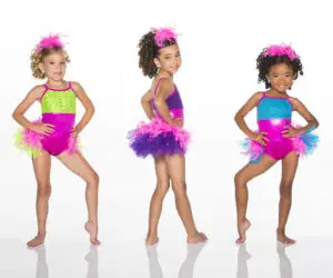 Three young dancers in colorful sequined costumes and feathered skirts