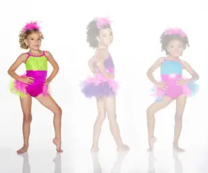Three young dancers wearing colorful feathered costumes pose.