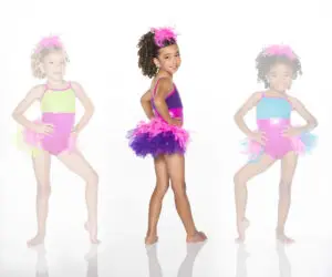 Three young dancers in colorful feathered costumes