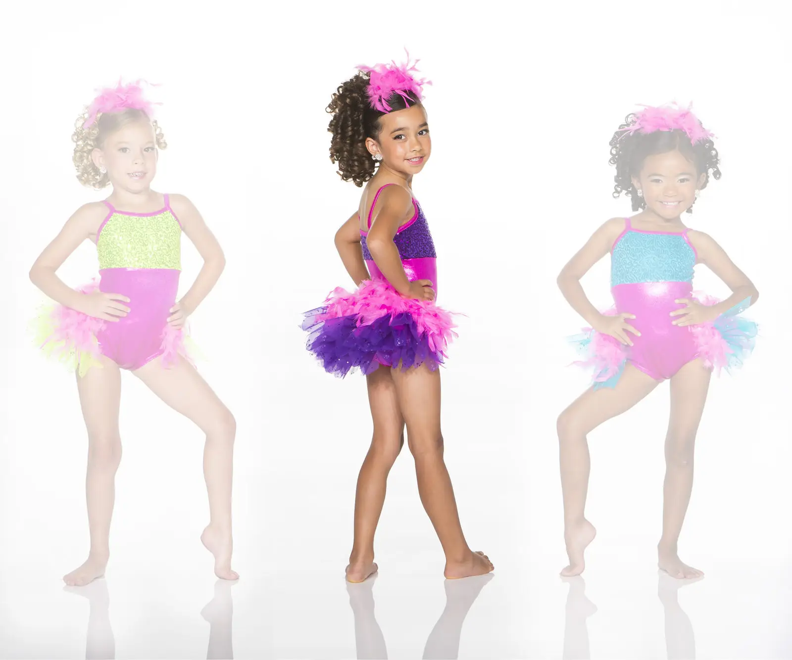 Three young dancers in colorful feathered costumes