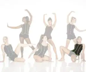 Five dancers pose in black costumes with colorful trim.