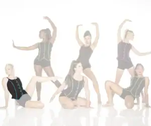 Five dancers pose in black costumes with colorful trim.