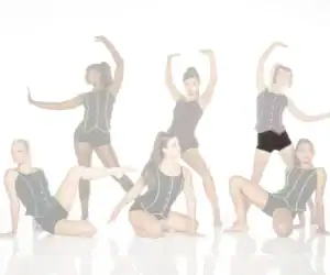 Five dancers posing in black costumes with colorful trim