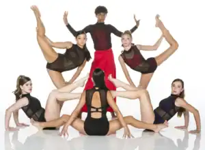 Five dancers pose in dramatic studio formation.