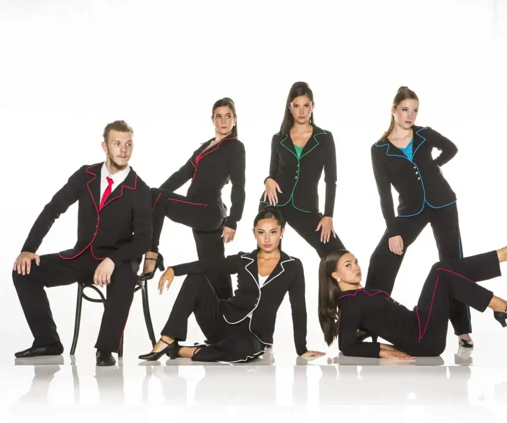 Six models in black suits with colorful piping pose