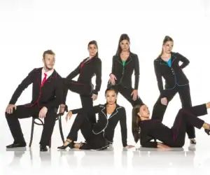 Six models in black suits with colorful piping pose