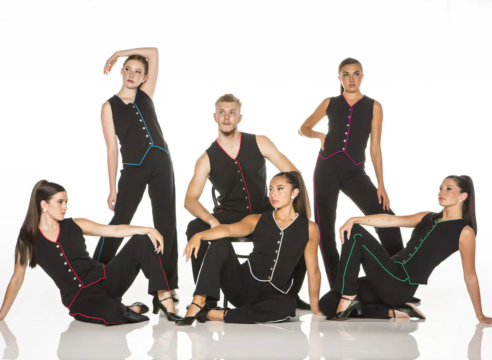 Six dancers pose in black outfits with colorful trim.