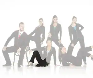 Six models wearing black suits with colorful piping.