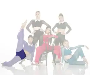Five dancers pose in colorful costumes around a chair.