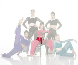 Five dancers posing in colorful costumes against white background