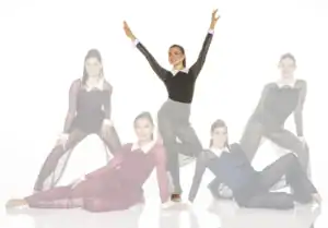 Five dancers in sheer black costumes posing on white background