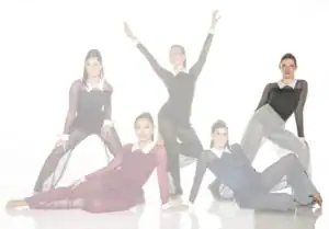Five female dancers pose in sheer black and colored costumes.