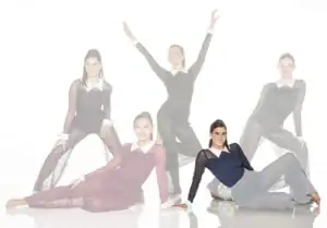 Five women in sheer black dance costumes posing together