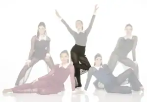 Five dancers pose in sheer black costumes against white background.