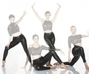 Four women in black dancewear posing against white background