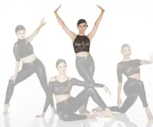 Four women in black lace tops and leggings posing