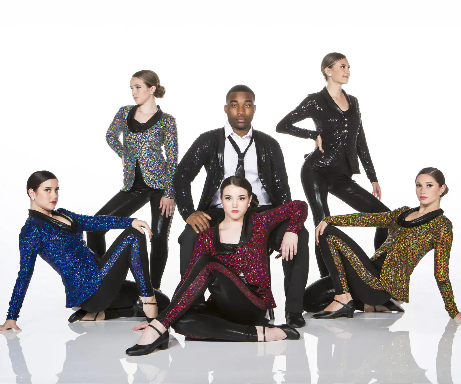 Five dancers pose in colorful sequined jackets and black attire.